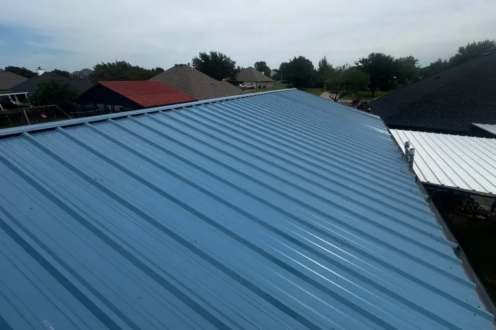 Blue standing-seam metal roof on a house, seen along the ridge